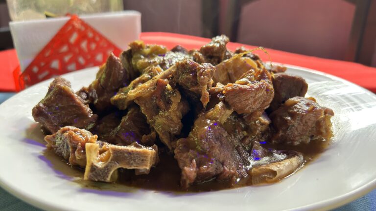 Costa Rican meal with fried chicken, rice and beans, cabbage salad, and fried plantains.